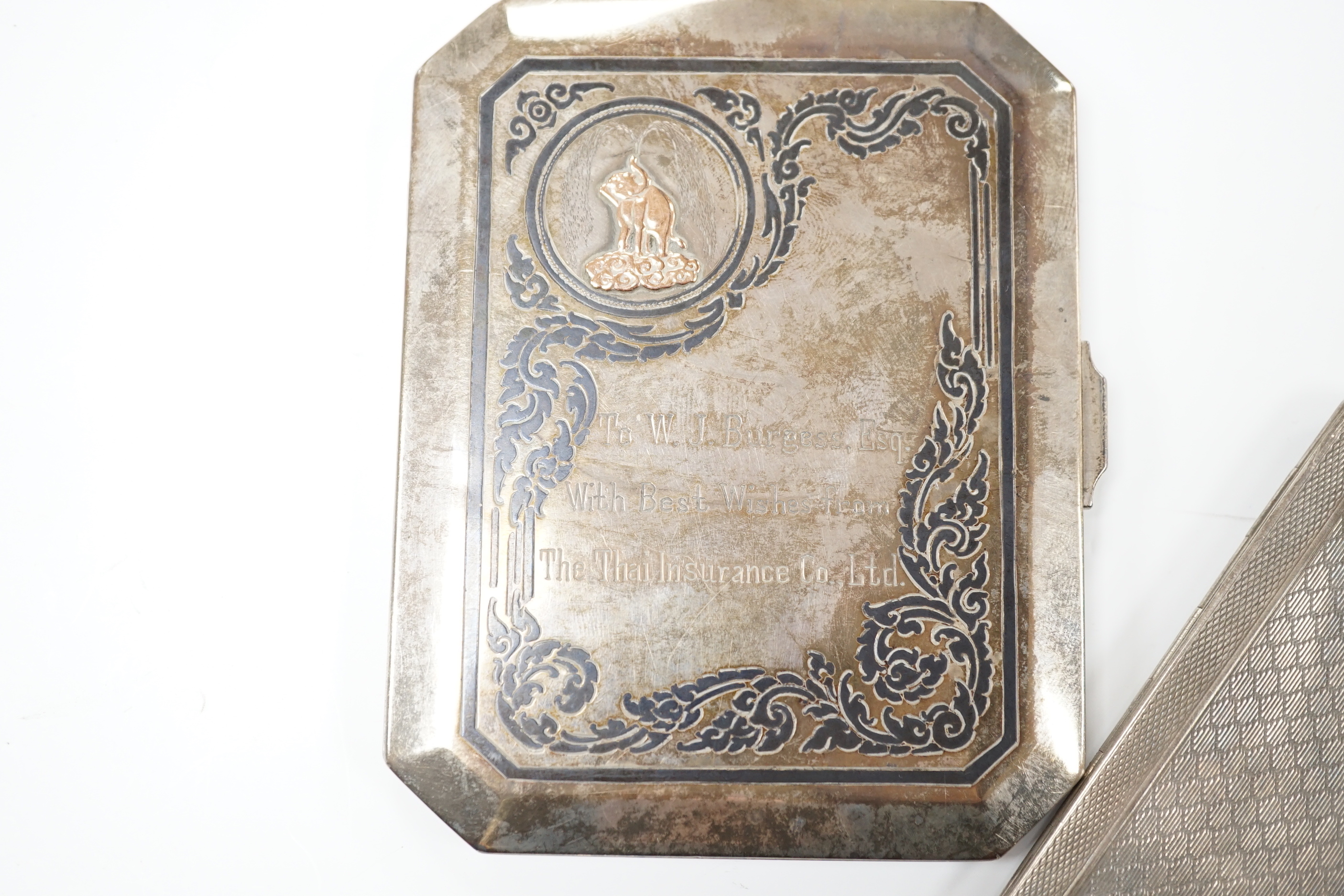 A George V engine turned silver cigarette case, 183 grams, and a Thai white metal and niello cigarette case